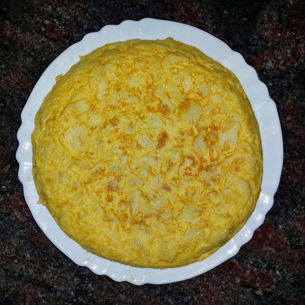Frittata alta e soffice appena sfornata, con ingredienti freschi e colori vivaci.