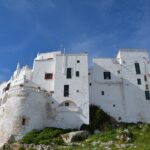 Vista panoramica del borgo pugliese con architetture storiche e strade acciottolate.