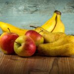 Cane che mangia un pezzo di mela, illustrando quali frutti sono sicuri per i cani.