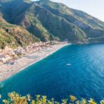 Baia nascosta in Liguria, con acque cristalline e scogliere affacciate sul mare.